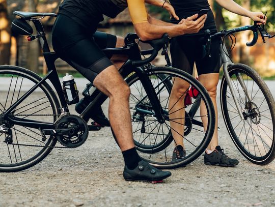 Na zdjęciu osoby jeżdżące na rowerze w butach rowerowych