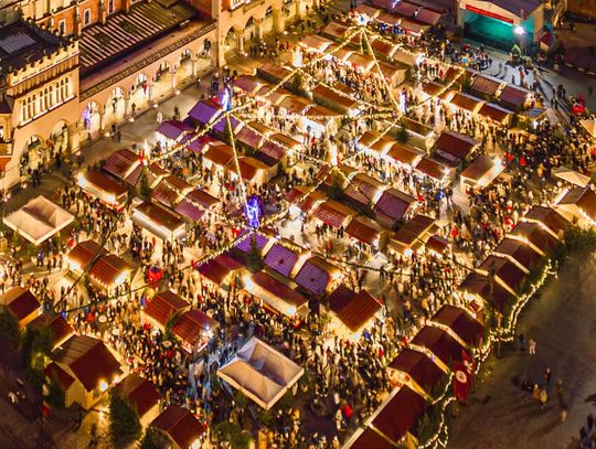 Stoiska na Jarmarku Bożonarodzeniowym w Krakowie widziane z góry. Pomiędzy stoiskami chodzą ludzie