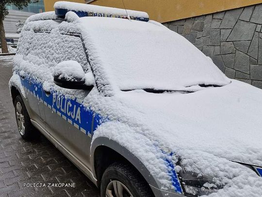 Na zdjęciu radiowóz policji przykryty warstwą śniegu