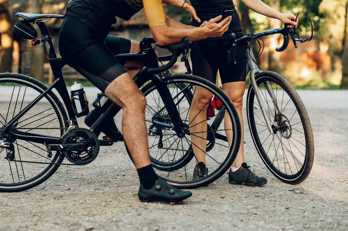 Na zdjęciu osoby jeżdżące na rowerze w butach rowerowych