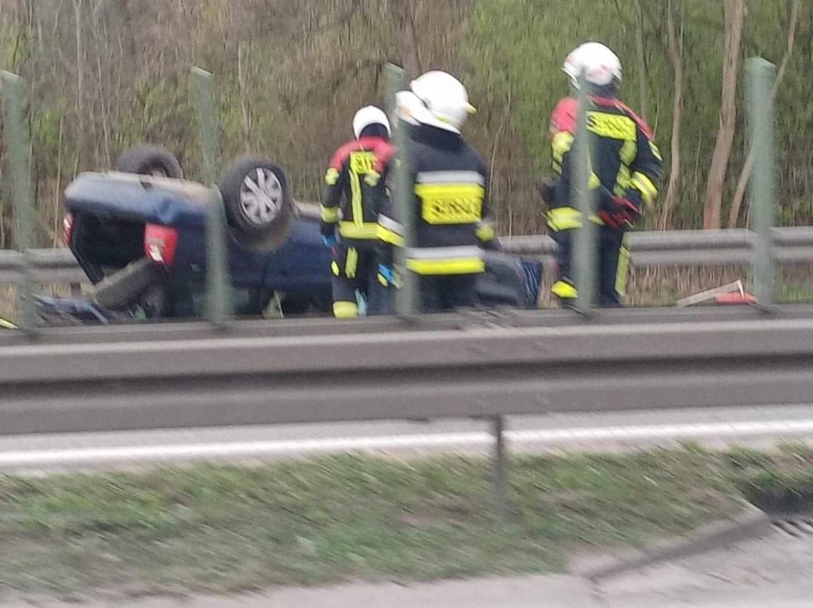 Na zdjęciu strażacy przy pojeździe, który dachował na autostradzie A4