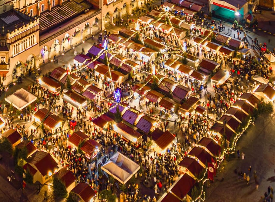 Stoiska na Jarmarku Bożonarodzeniowym w Krakowie widziane z góry. Pomiędzy stoiskami chodzą ludzie