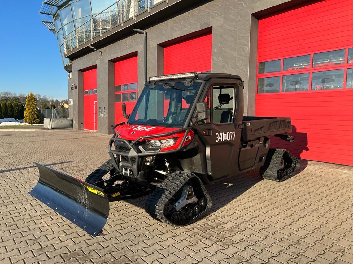 Na zdjęciu wielofunkcyjny pojazd typu UTV z alternatywnym napędem gąsienicowym oraz przyczepą do jego transportu. Marka pojazdu to Can-Am TRAXER PRO HD10T