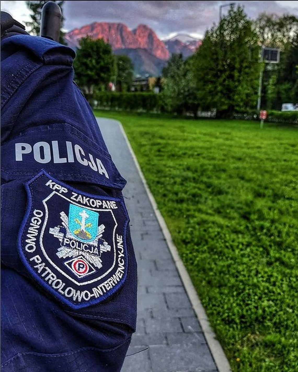 Policjant w mundurze na tle gór.