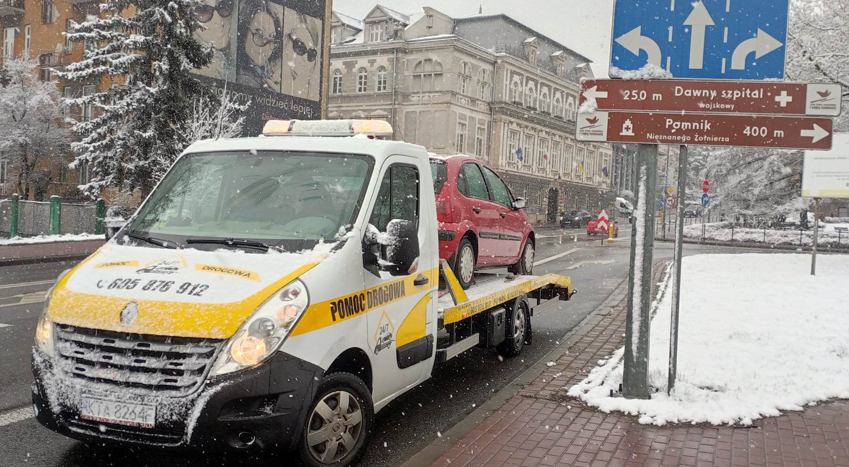 Laweta w Tarnowie holuje samochód po awarii na zaśnieżonej drodze